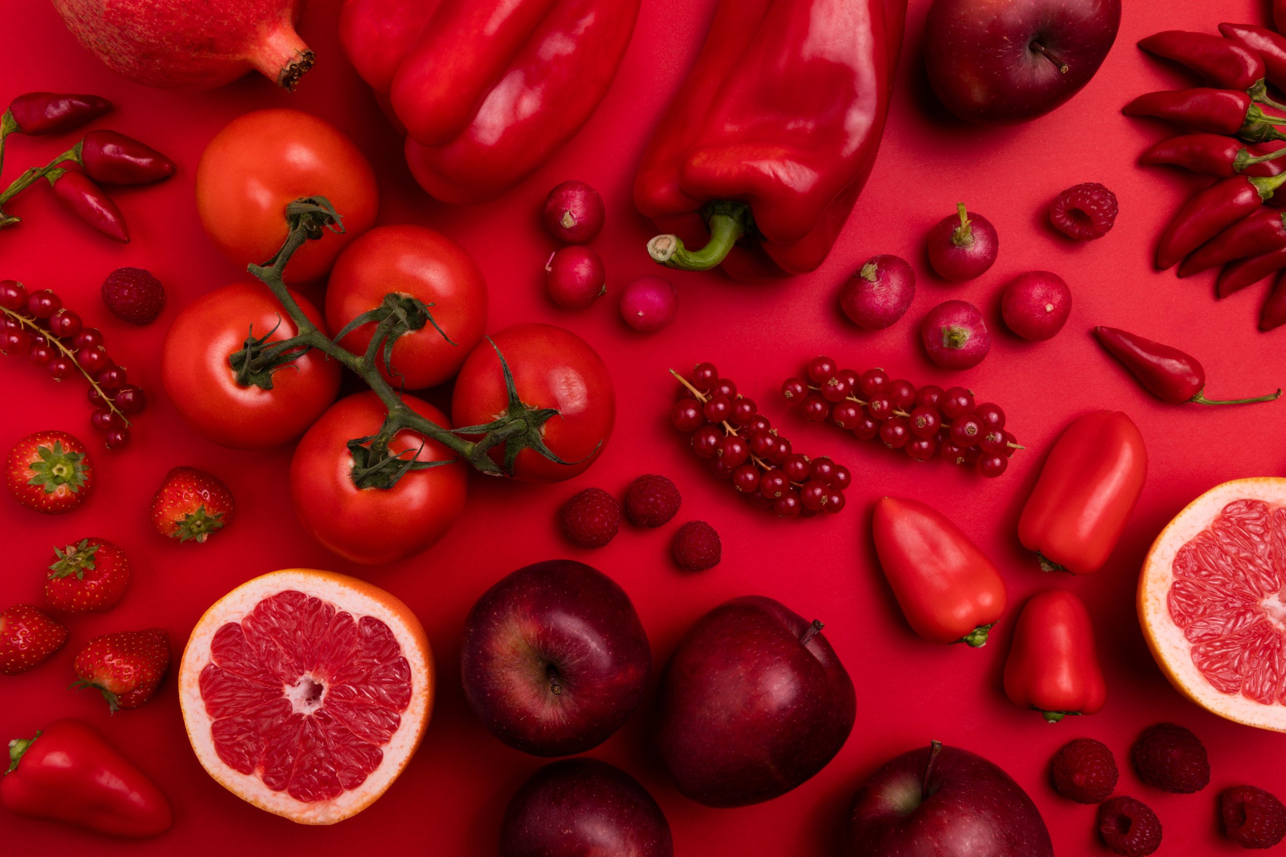 Assorted Red Fruits and Vegetables on Red Background